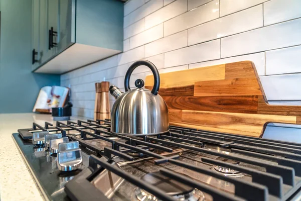 Interior de la cocina con hervidor de agua sobre el quemador de una encimera con cinco perillas — Foto de Stock