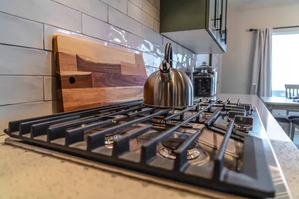 Крышка с кастрюлей над горелкой и чугунной решеткой внутри жилой кухни — стоковое фото