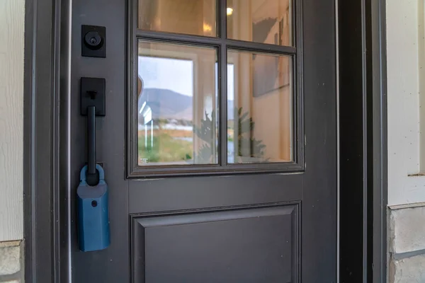 Puerta delantera con bisagras de madera gris del hogar con paneles de vidrio mango negro y cerradura — Foto de Stock