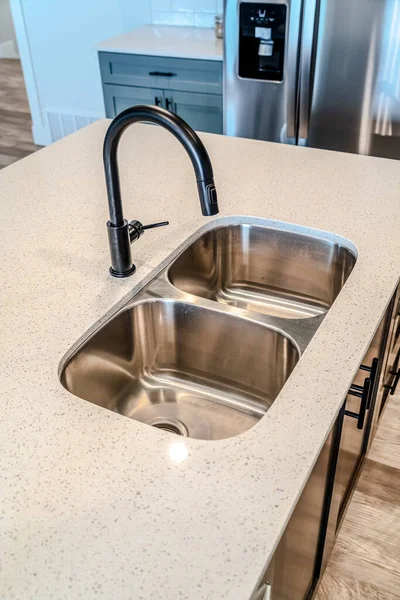 Kitchen island with black curved faucet and double basin undermount sink