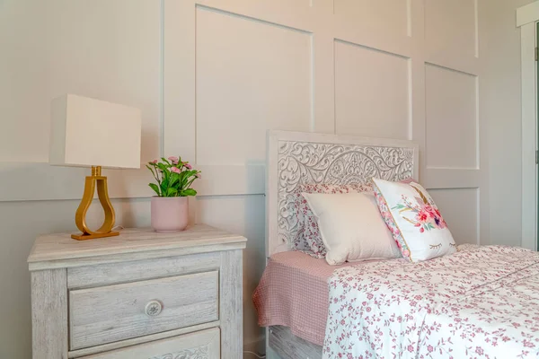 Bed with decorative head board against white panelled wall of feminine bedroom — Stock Photo, Image