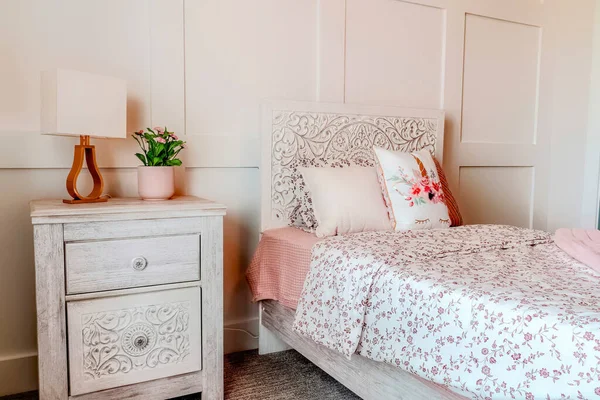 Floral bedpread and fluffy pillows on a bed inside bedroom with feminine design — Stock Photo, Image