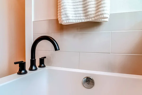 Vista da vicino del rubinetto a collo d'oca nero sul bordo di una vasca da bagno all'interno del bagno — Foto Stock