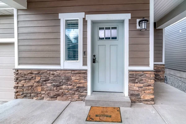 Glass paned front door and sidelight against brick wall and wood siding of home — Stock Photo, Image