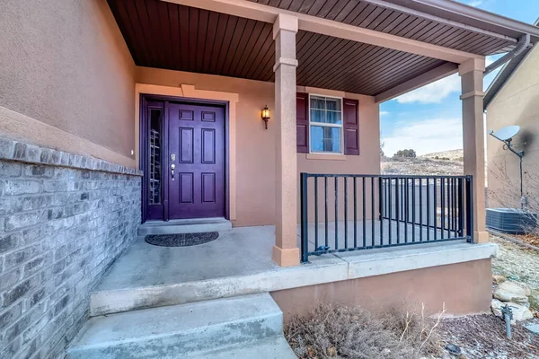 Entrada de casa con escaleras que conducen al porche y puerta frontal púrpura con corona — Foto de Stock