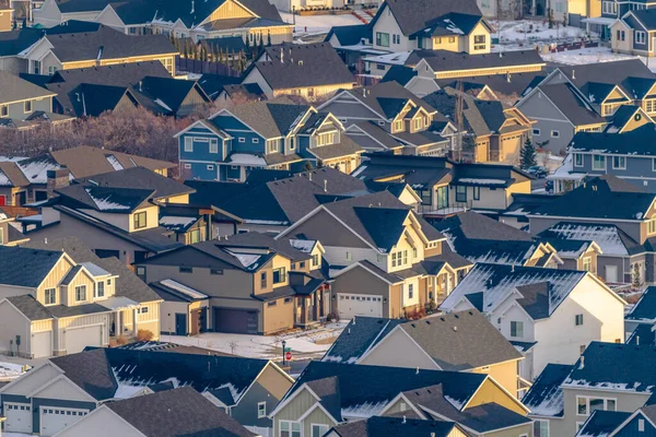 Luftaufnahme von Häusern auf einer sonnenbeschienenen und verschneiten Wohnsiedlung im Winter — Stockfoto