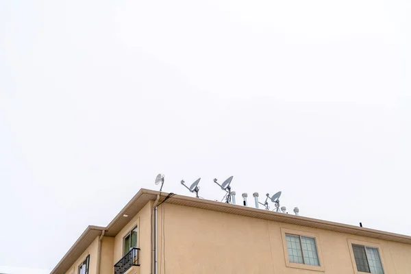 Edifício residencial com antenas parabólicas parabólicas instaladas no telhado — Fotografia de Stock
