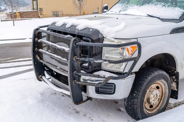 Vista frontal del vehículo blanco con protector de rejilla estacionado en carretera nevada en invierno — Foto de Stock