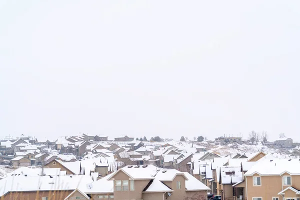 Vista aérea de casas con techos nevados contra el cielo nublado en un paisaje invernal — Foto de Stock