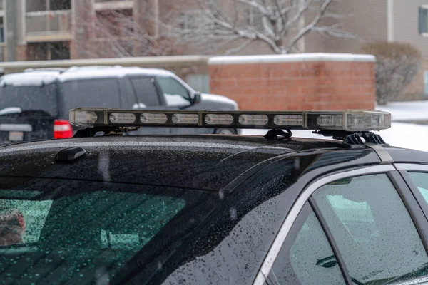 Light bar mounted on the wet roof of a parked black police car on a rainy day — Stock Photo, Image