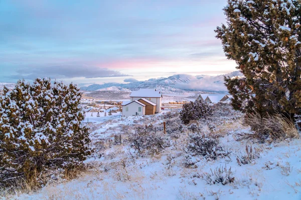 Gün batımında karlı bir mahallede güzel dağ ve bulutlu gökyüzü manzarası — Stok fotoğraf