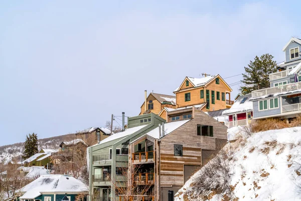Paisaje residencial de viviendas construidas en comunidad de montaña con laderas nevadas — Foto de Stock