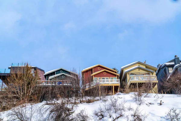 Kışın karlı doğa manzaralı balkonları olan renkli evler. — Stok fotoğraf