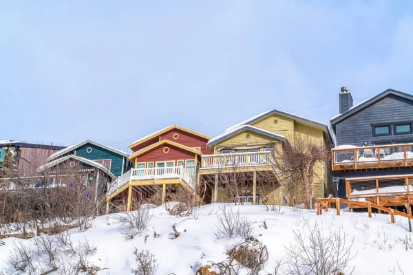 Kışın karla kaplı manzaralı dağlık arazide inşa edilmiş renkli evler. — Stok fotoğraf