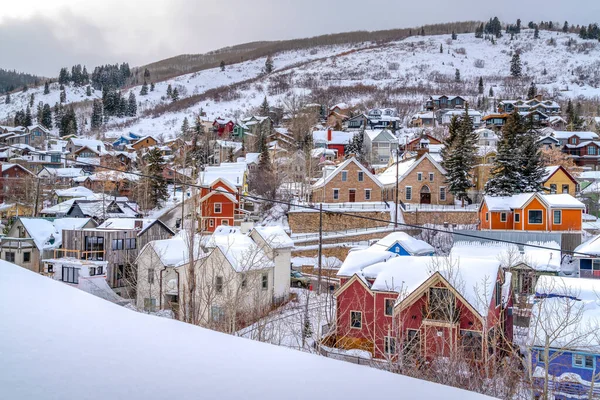 Casas de montaña contra un paisaje blanco y verde de nieve y árboles en invierno — Foto de Stock