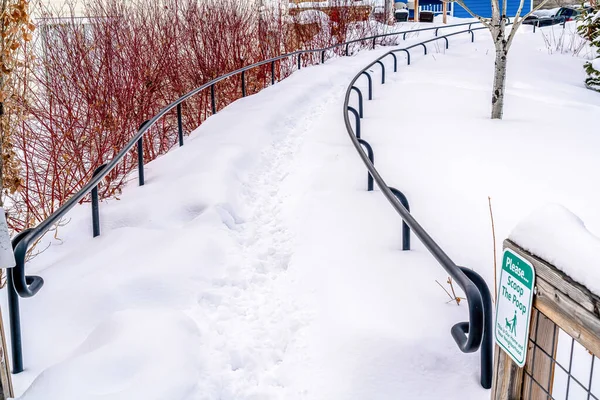 Weg mit Geländern, die im Winter in einem malerischen Viertel unter Schnee begraben wurden — Stockfoto