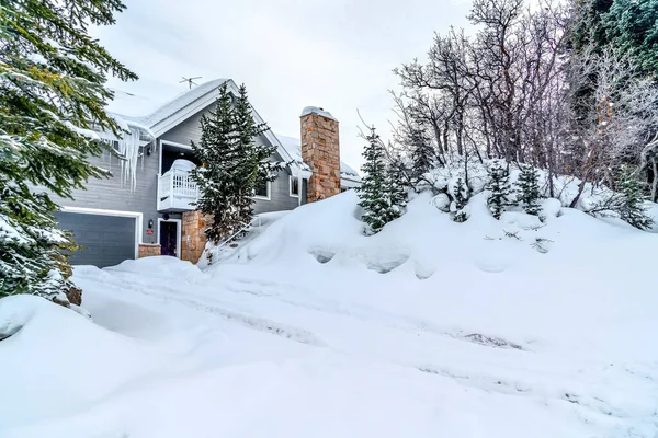 Häuserfassade und schneebedeckter Hang gegen wolkenverhangenen Himmel in einer Winterlandschaft — Stockfoto