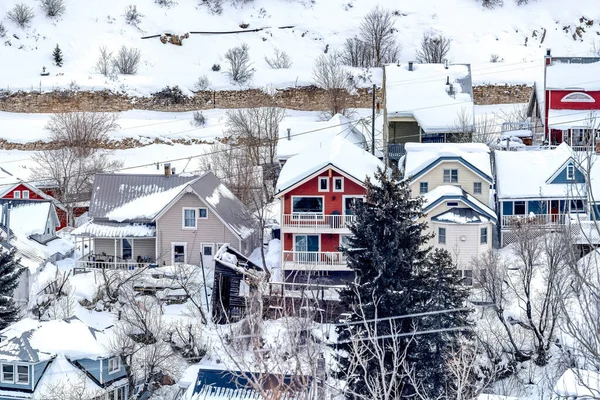Krásné rodinné domy v malebné čtvrti ve zasněžených horách v zimě — Stock fotografie