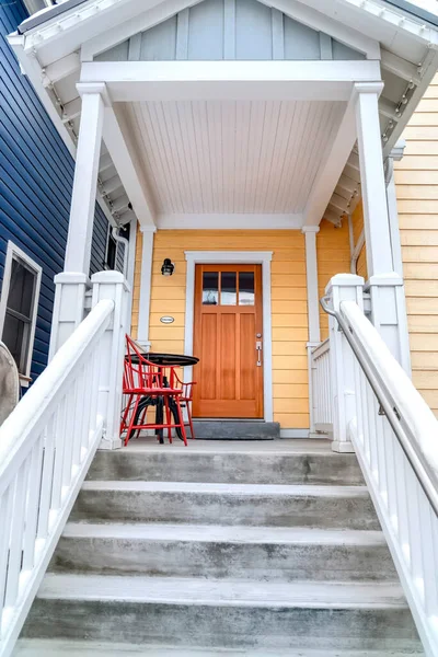 Entrada em casa com telhado de duas águas sobre escadas e porta dianteira marrom com vidros — Fotografia de Stock