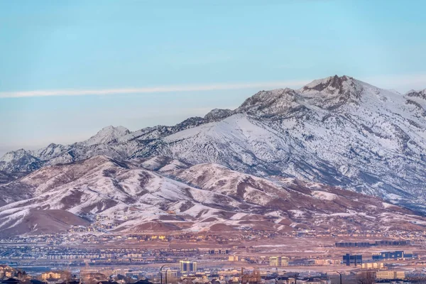 Εντυπωσιακή θέα στο βουνό σε ένα χιονισμένο χειμερινό τοπίο ενάντια χλωμό γαλάζιο ουρανό — Φωτογραφία Αρχείου