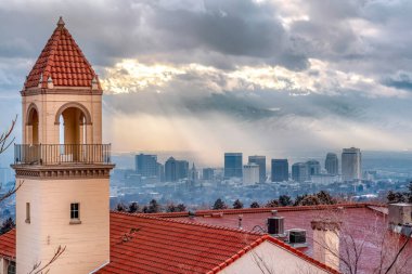 Çan kulesi ve kilisenin kırmızı çatısı sisli Salt Lake City manzarasına karşı
