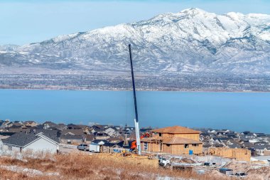 Mahalle, kışın göl ve karlı dağ manzarasına karşı.