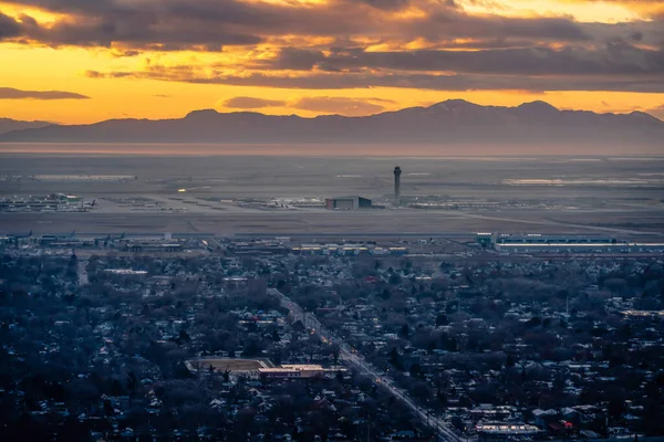Vista aérea panorâmica da cidade com montanha silhueta e céu dourado ao pôr do sol — Fotografia de Stock