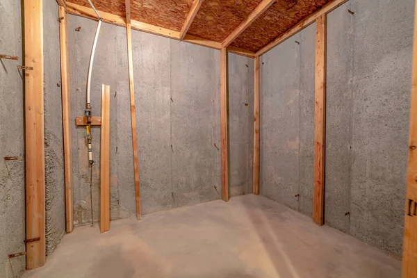 Intérieur de la pièce en construction avec poutres en bois contre mur en béton — Photo