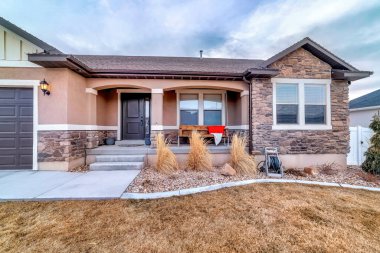 Bahçeye bakan verandasında salıncak olan taştan ev cephesi.