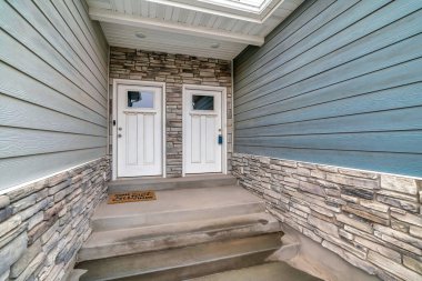 Aynı beyaz tahta ön kapılar. Taş duvarlara cam camlar takılmış.