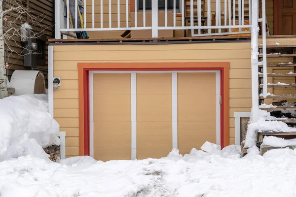 Esterno di un garage auto singola allegata di casa con vialetto innevato in inverno — Foto Stock