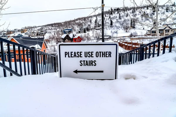 Kérjük, használja más lépcsők jel egy járhatatlan lépcsőn a havas környéken — Stock Fotó