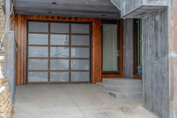 Porte avant en verre et porte de garage vitrée de la maison contre le bois et le mur de briques — Photo