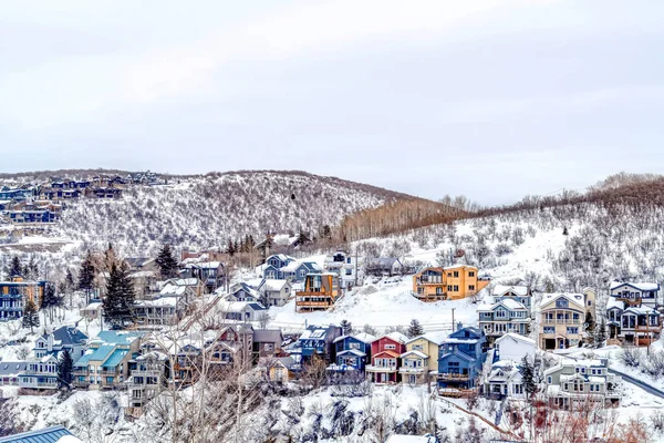 在多雪的冬季风景中，山城的房屋与多云的天空相映衬 — 图库照片