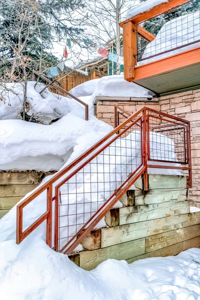 Outdoor stairs of hill home covered with thick layer of snow in winter