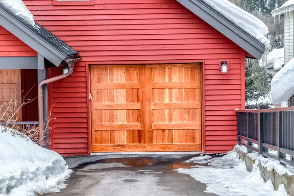 Braune Holztür einer angebauten Garage mit leuchtend roter Außenwand — Stockfoto