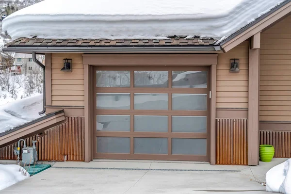 Glass paned garage door of home in the mountain blanketed with snow in winter