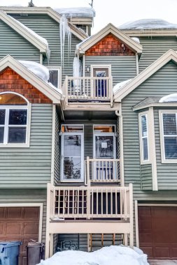 Evin girişlerinde cam kapılar ve kışın karlı çatılarda buz saçakları vardı.