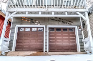 Karlı bir kış gününde, iki arabanın garajının camlı kahverengi kapısı.