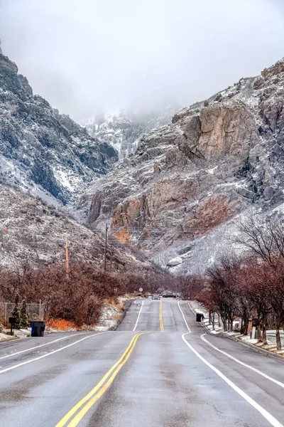 Carretera a lo largo de paisaje escénico de escarpada montaña rocosa y cielo nublado — Foto de Stock