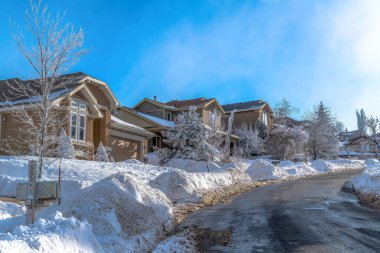 Donmuş dağ kasabasında yol boyunca evler kışın taze karla kaplı.