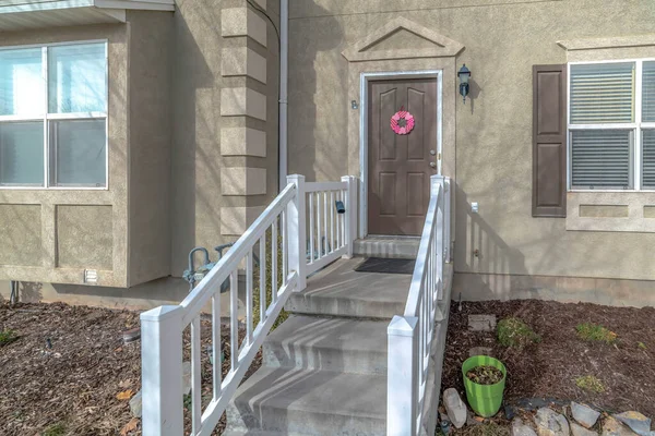 入口有混凝土楼梯、木制扶手和棕色前门的家 — 图库照片