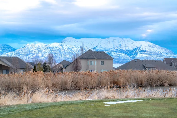 Сообщество долины Юта на зимней сцене с домом пруд и Wasatch Mountain — стоковое фото