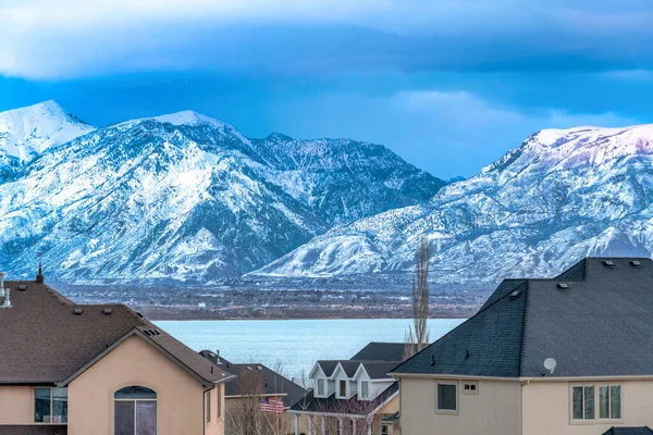 Montaña cubierta de nieve y lago azul en el vasto valle pintoresco con casas —  Fotos de Stock