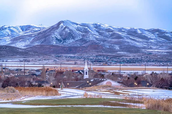 Comunidad en el valle cubierto de nieve con lago pintoresco y majestuosas vistas a la montaña — Foto de Stock