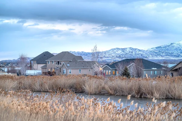 Maisons avec vue sur l'étang et la montagne Wasatch dans un cadre hivernal enneigé — Photo
