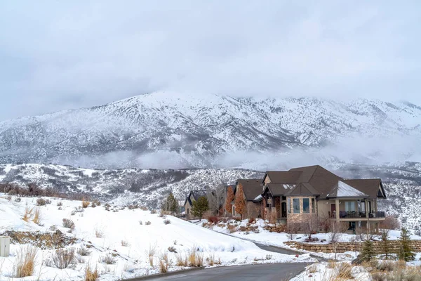 Casas que se mezclan con el terreno cubierto de nieve contra Wasatch Mountain en invierno — Foto de Stock