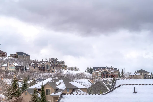 Casas de montaña en un frío entorno nevado bajo el cielo gris nublado en invierno — Foto de Stock