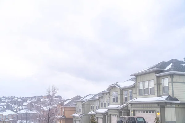 Kış mevsiminde karlı ve sisli bir ortamda bulutlu gökyüzünün altındaki evler — Stok fotoğraf