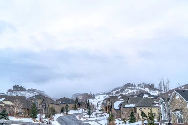 Paisaje escénico de montaña con casas a lo largo de la carretera en medio de la nieve en invierno — Foto de Stock